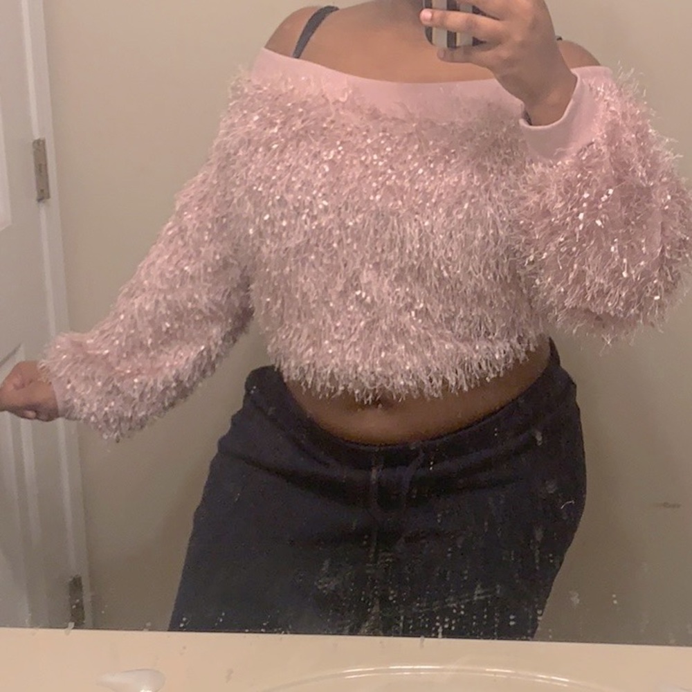 A pink fluffy off the shoulder sweater